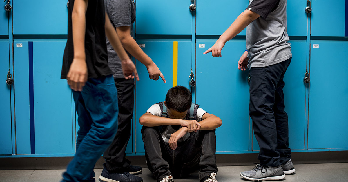tween boy being bullied in school hallway