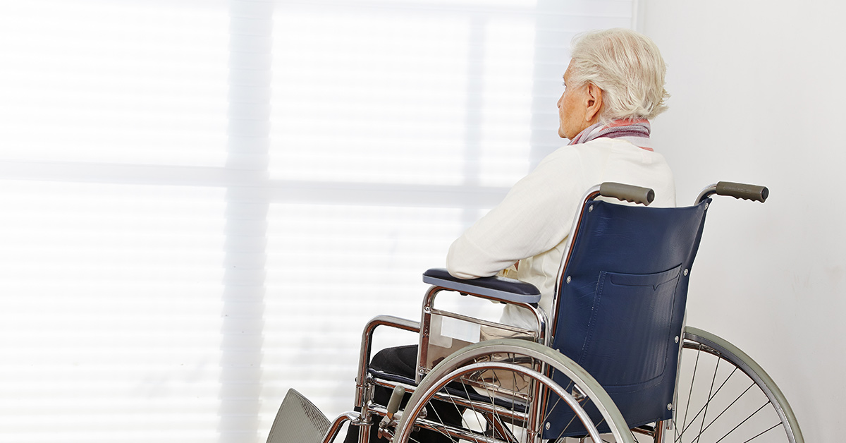 elderly woman in wheelchair looking out a window