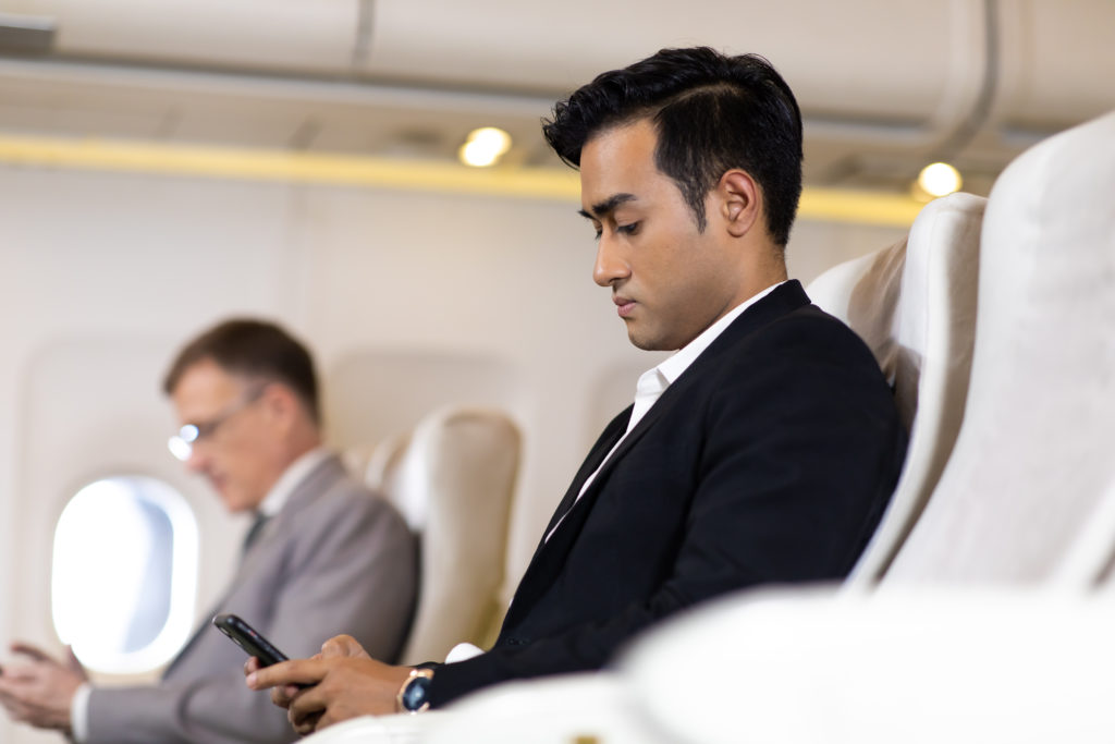 man in first class using cell phone