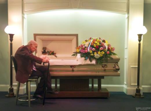 Lonely Widower Sits near Wife's Coffin