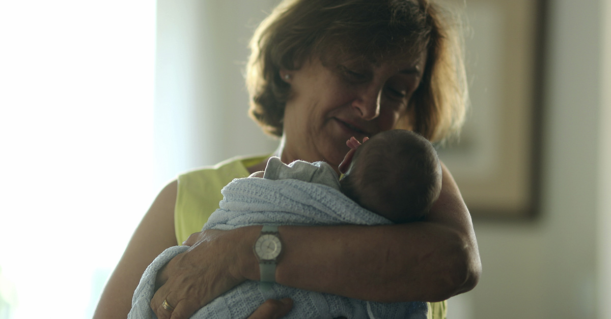 middle aged woman holding infant